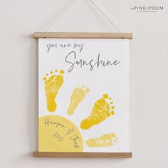 a hand and foot print hangs on the wall next to a sign that says, you are my sunshine