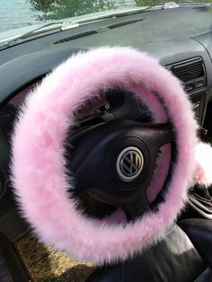 a steering wheel cover with pink fur on it