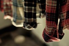 a plaid shirt hanging from the side of a sink in front of a faucet