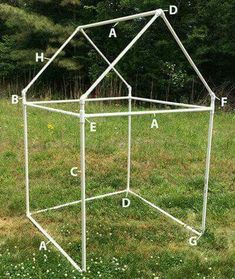 a white metal structure sitting on top of a grass covered field with words written in front of it