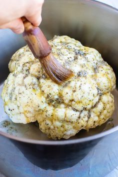 the cauliflower is being stirred with a brush