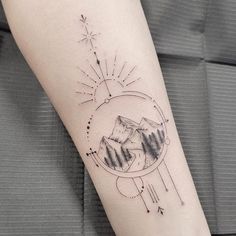 a person with a tattoo on their arm that has mountains and stars in the sky