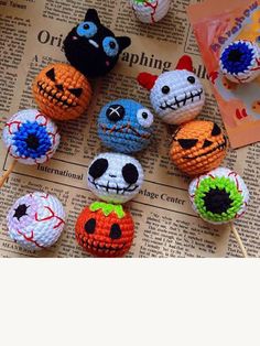 there are many crocheted pumpkins on the table with toothpicks in them