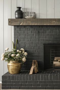 a living room with a fire place and vases on top of the mantel