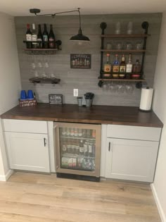 a kitchen with white cabinets and shelves filled with bottles