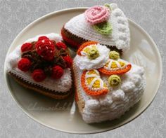 three crocheted pieces of food on a white plate with red and yellow flowers