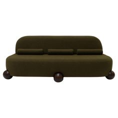 a green couch sitting on top of a wooden base