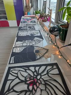 the long table is decorated with black and white paper cutouts, string lights, and potted plants