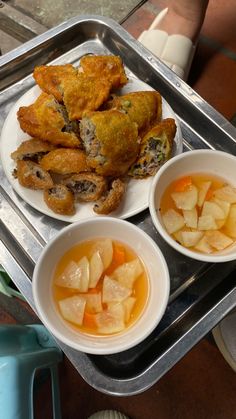 three bowls of food are sitting on a tray