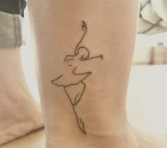 a woman's foot with a small tattoo on the ankle that has a ballerina in it