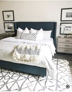 a bed with white linens and pillows in a small room next to pictures on the wall