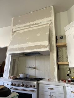 the kitchen is being remodeled with white paint on the cabinets and stove top, which needs to be replaced