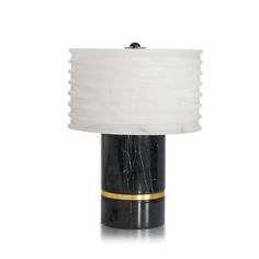 a black and white table lamp with a gold stripe around the base on a white background