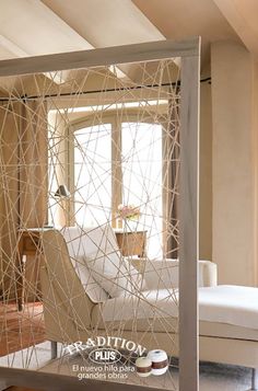 a white chair sitting next to a window in a room