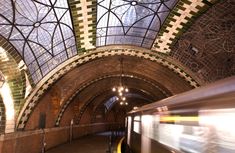 a subway train passing by an ornate ceiling