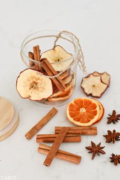 an apple, cinnamon and star anise on a white counter top with some cut up apples