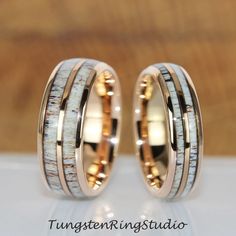 two wedding rings with antler wood and gold inlays on each one side