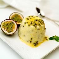 a white plate topped with fruit covered in sauce and garnished with green leaves