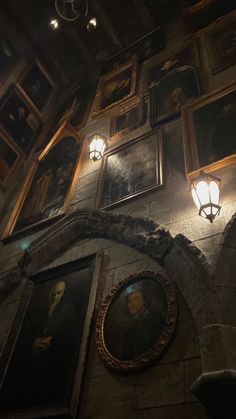 an old building with some paintings on the wall and lights hanging from it's ceiling