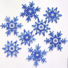 six blue snowflakes are arranged on a white surface