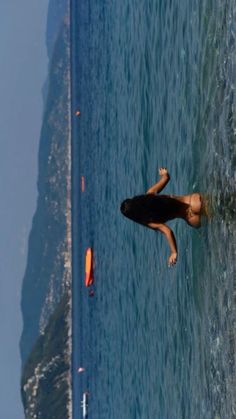 a woman is swimming in the ocean with her surfboard