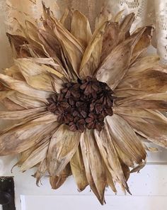 a large dried sunflower sitting on top of a window sill