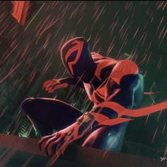 a spider man sitting on top of a ledge in the rain