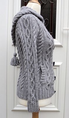 a mannequin wearing a gray sweater with tassels