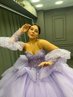 a woman in a purple dress posing for the camera with her hands on her head