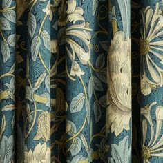 blue and white floral curtains with gold trimmings on the bottom half of them