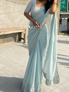 a woman in a blue sari and white blouse