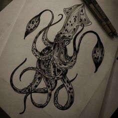 an octopus drawing on paper next to a marker and pen with some ink in it