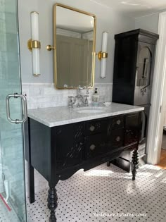 a black and white bathroom with gold accents