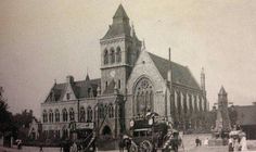 an old black and white photo of a horse drawn carriage in front of a church