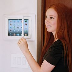 a woman is using an appliance on the wall