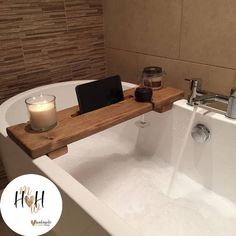 a bath tub with a wooden tray and candle