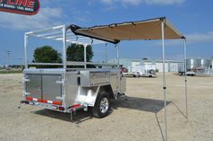 a silver trailer with a canopy attached to it