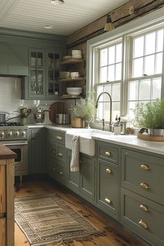 a kitchen filled with lots of green cabinets and counter top space next to a window