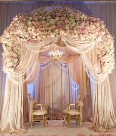 an image of a wedding ceremony with flowers on the stage and draping curtains