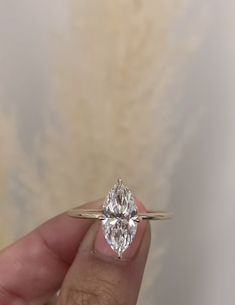 a person holding a ring with a diamond in it's center and the other hand