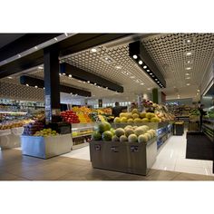 the produce section of a grocery store with fresh fruits and vegetables on display in bins