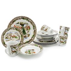 a set of christmas dinnerware including cups and saucers, decorated with winter scenes