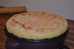 a pancake sitting on top of a stove next to a rolling pin