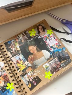 an open notebook with pictures and scissors on it next to a pair of shears