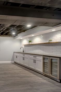 an empty kitchen with white cabinets and stainless steel appliances