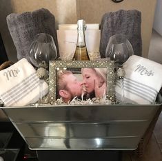 a couple kissing in front of a mirror with towels and wine glasses on the table