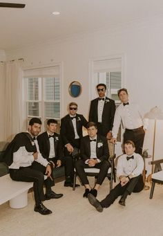 a group of men in tuxedos are posing for a photo together on the couch