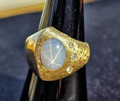 a close up of a gold ring with a white stone on it's center