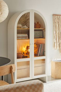 an arched glass cabinet with books inside