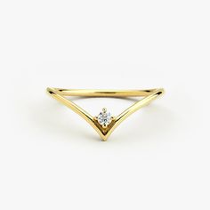 a yellow gold ring with a single diamond in the middle, on a white background